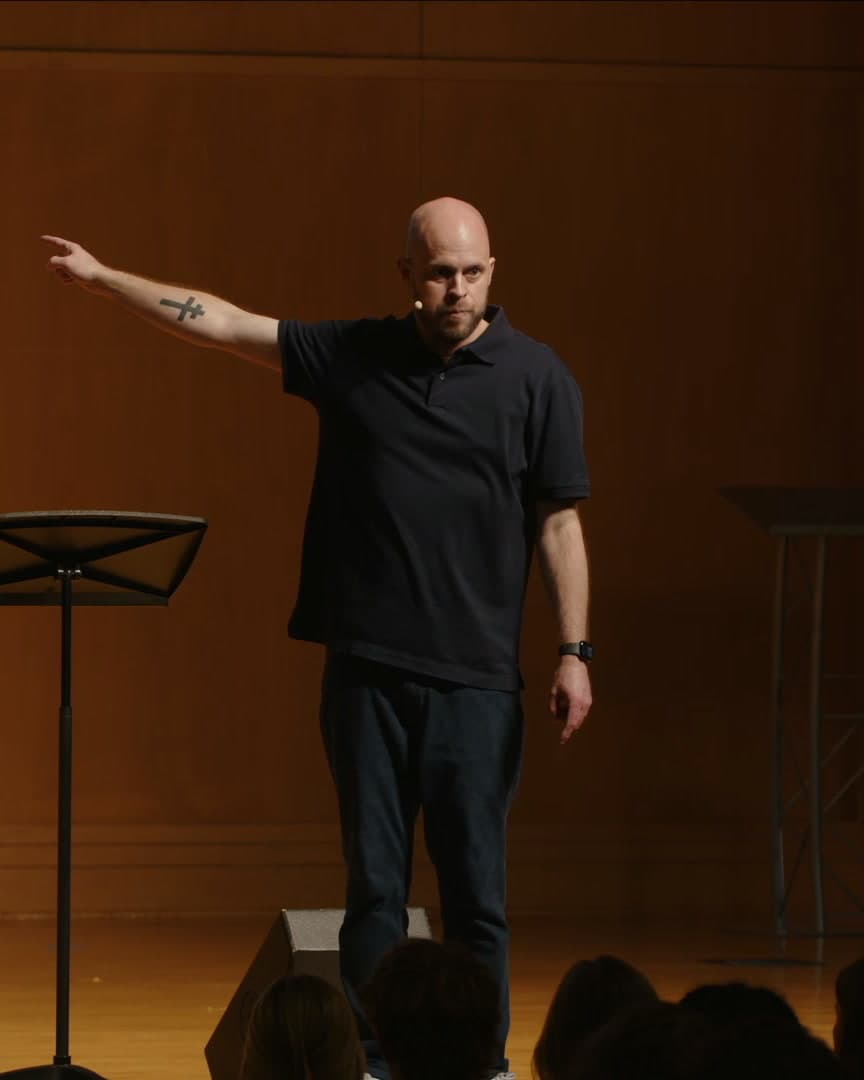 Mike Skinner pointing across the stage while speaking